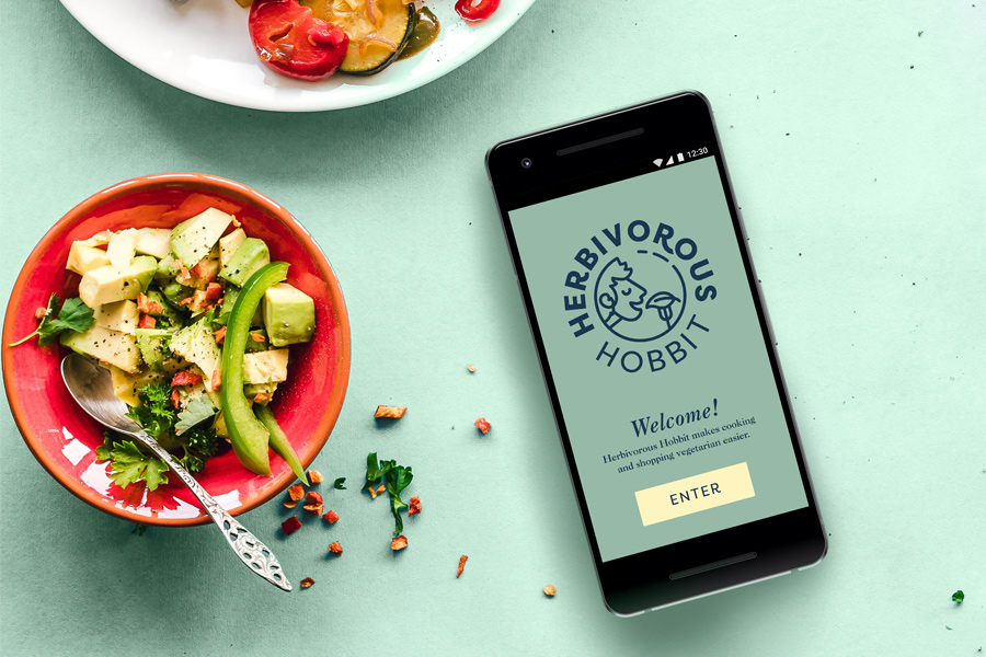 Herbivorous Hobbit cooking app shown on black smartphone next to bowls of food
