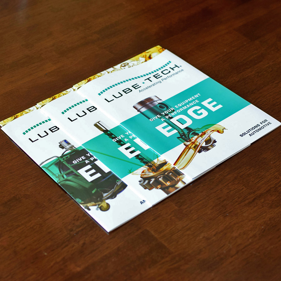 3 die-cut oil brochures on wooden surface
